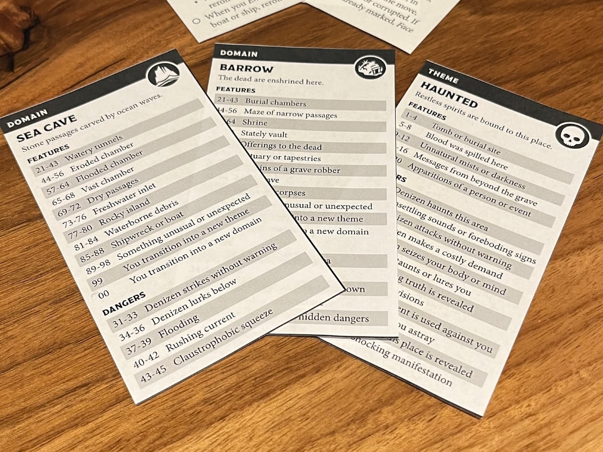 two domain cards and one theme card from ironsworn: delve. they depict a sea cave that is also a series of barrows that are haunted.